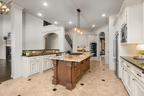 a kitchen with kitchen island granite countertop a counter space dining table and stainless steel appliances