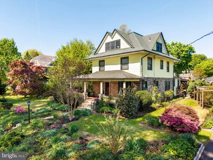 a front view of a house with a yard and fountain in middle