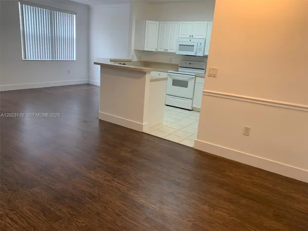 a kitchen with granite countertop white cabinets and white appliances