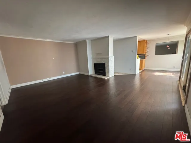 an empty room with wooden floor and fireplace