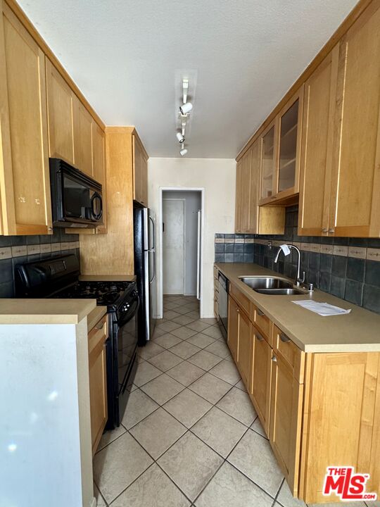 12030 Rochester Avenue, Unit 207 Los Angeles, CA 90025 - Photo 6 of 12 a large kitchen with stainless steel appliances granite countertop a sink and a stove