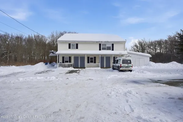 a front view of a house with a yard covered in snow