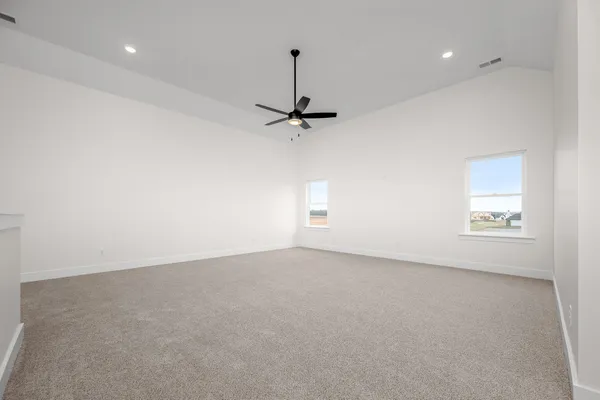 a view of an empty room with a window and chandelier