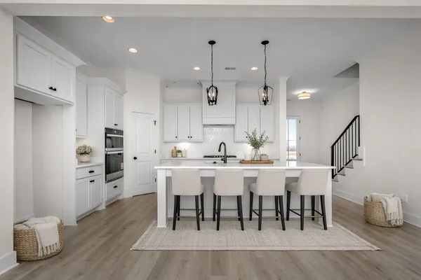 a kitchen with kitchen island granite countertop a sink cabinets and stainless steel appliances