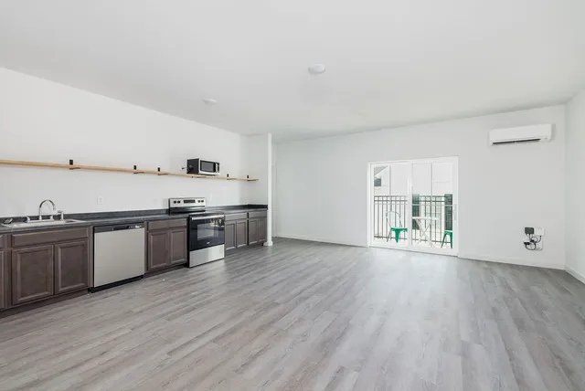 a large kitchen with a wooden floor and stainless steel appliances