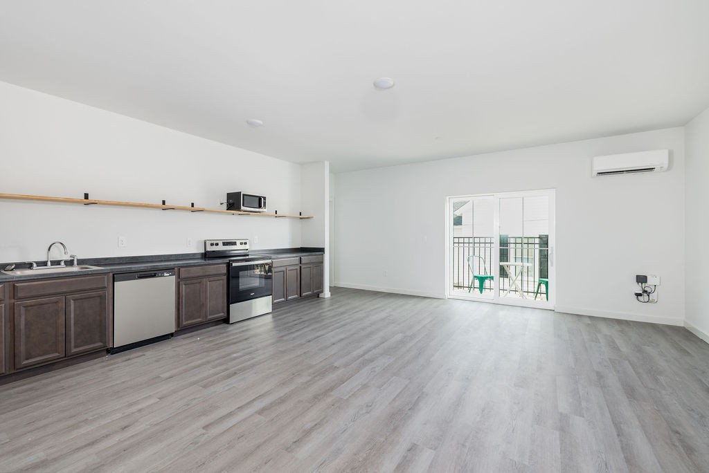 a large kitchen with a wooden floor and stainless steel appliances