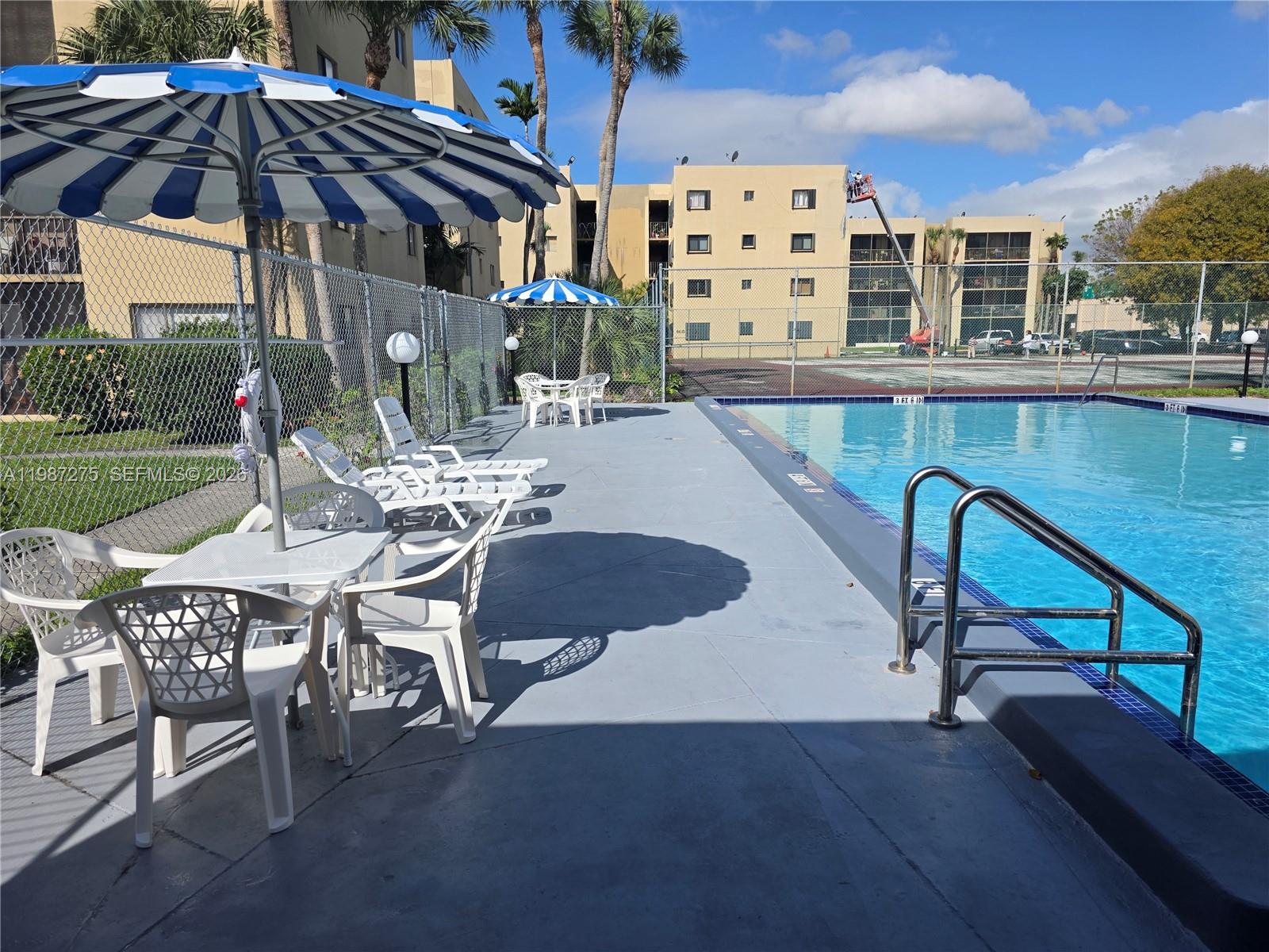 8615 Northwest 8th Street, Unit 319 Miami, FL 33126 - Photo 16 of 19 a patio with table and chairs