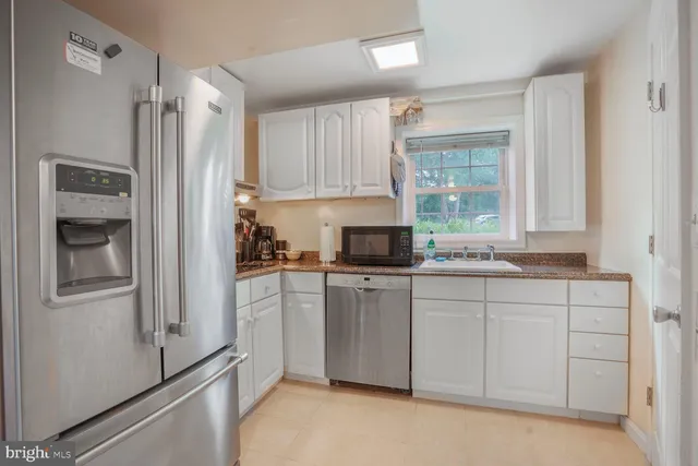 a kitchen with a refrigerator sink and cabinets