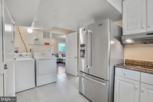 a kitchen with refrigerator and cabinets