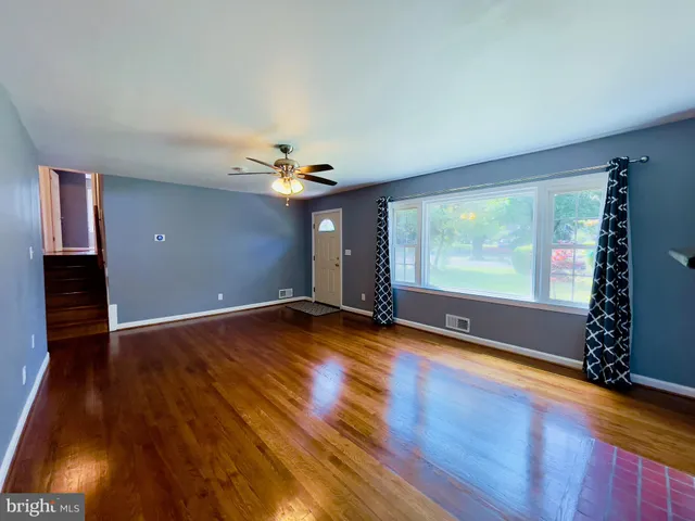 a view of room with window ceiling fan and hardwood floor