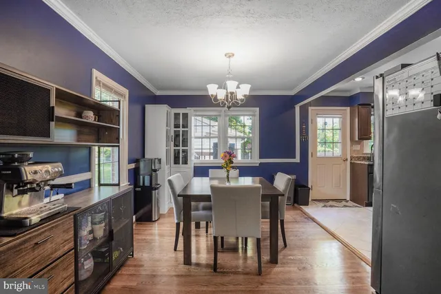 a view of a dining room with furniture a chandelier and wooden floor
