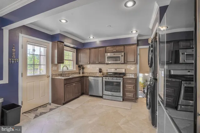 a kitchen with granite countertop a refrigerator stove and oven