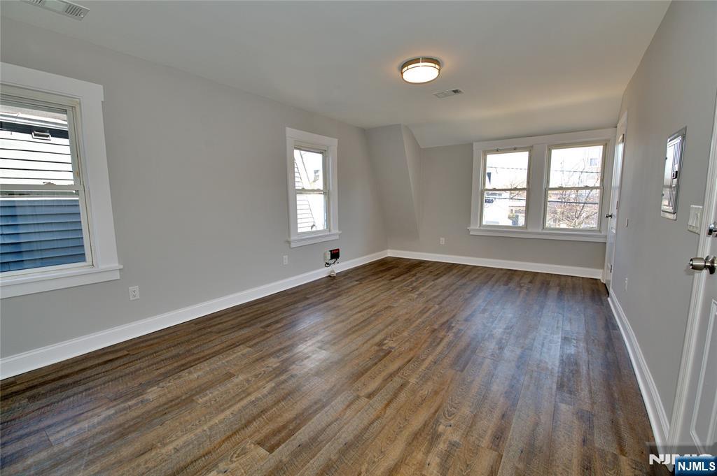 116 Maple Avenue, Unit 3 Montclair, NJ 07042 - Photo 3 of 12 a view of an empty room with wooden floor and a window