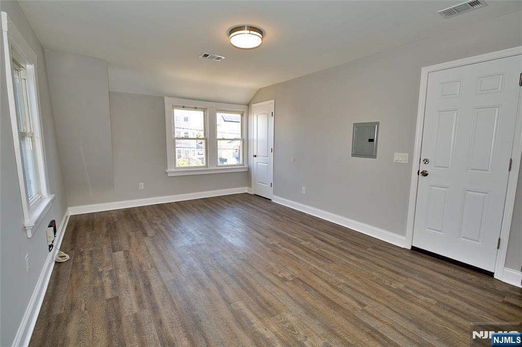 116 Maple Avenue, Unit 3 Montclair, NJ 07042 - Photo 5 of 12 an empty room with wooden floor and windows