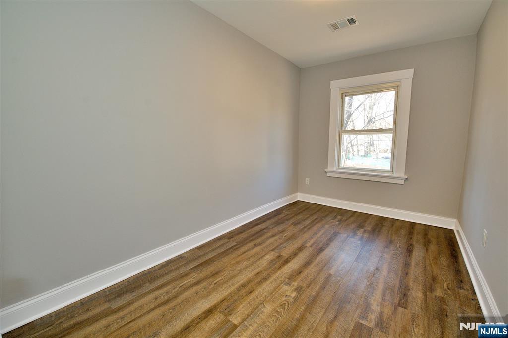116 Maple Avenue, Unit 3 Montclair, NJ 07042 - Photo 9 of 12 an empty room with wooden floor and windows