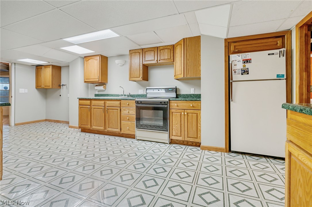 1010 Knollwood Road Northwest Canton, OH 44708 - Photo 33 of 47 Kitchen featuring white appliances, light tile floors, and a paneled ceiling