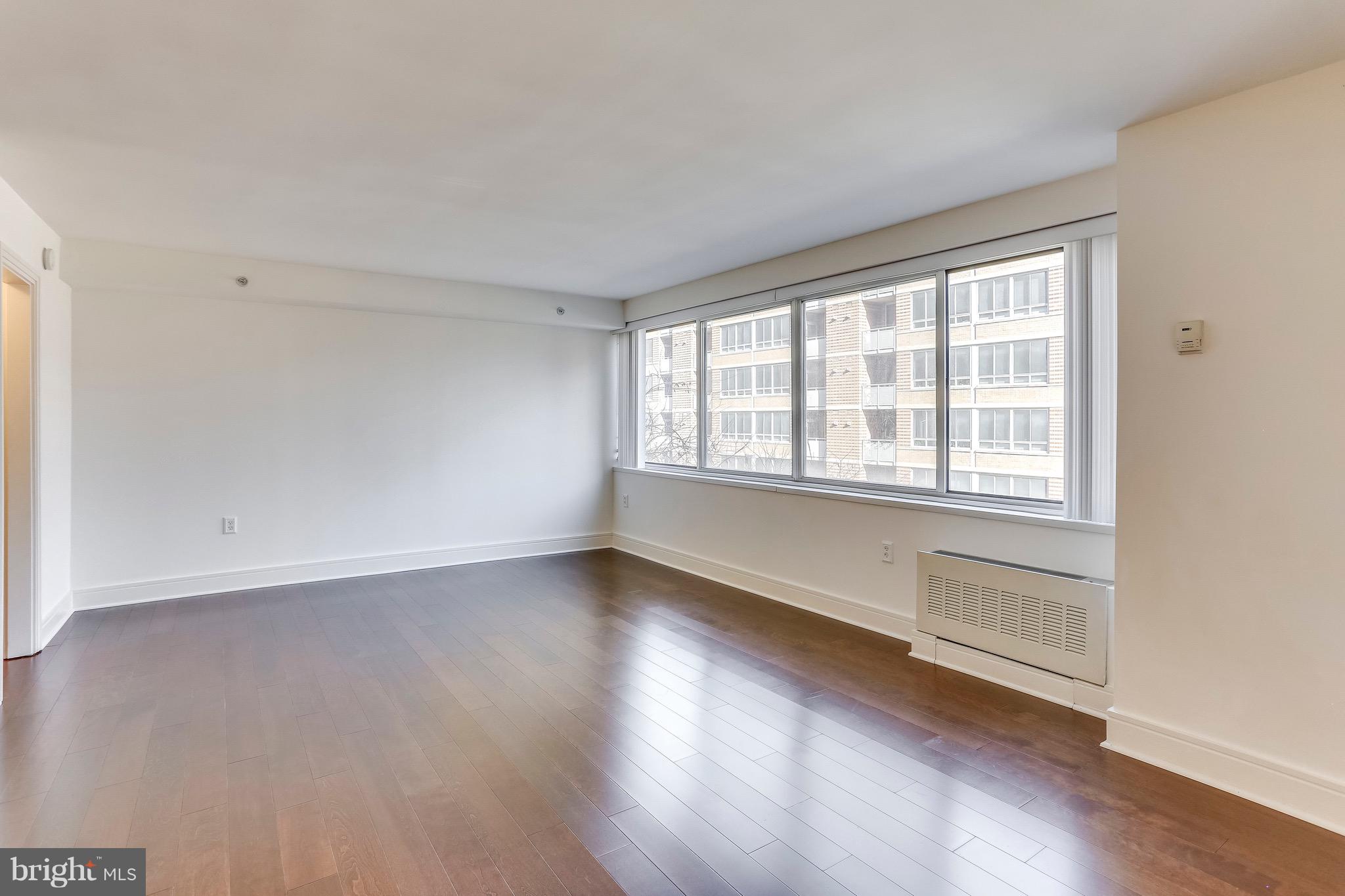 800 4th Street Southwest, Unit N111 Washington, DC 20024 - Photo 14 of 35 an empty room with wooden floor and windows