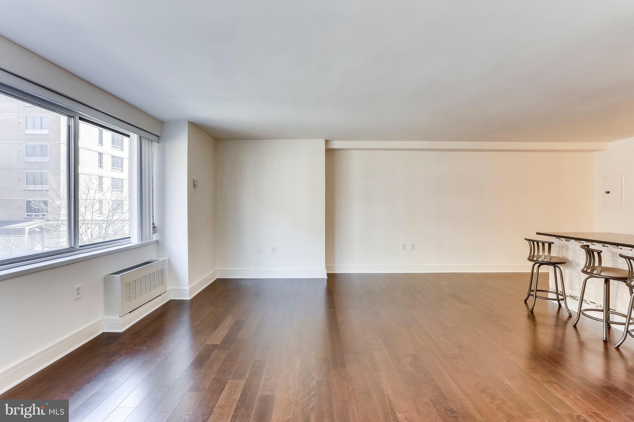 800 4th Street Southwest, Unit N111 Washington, DC 20024 - Photo 15 of 35 a view of an empty room with wooden floor and a window