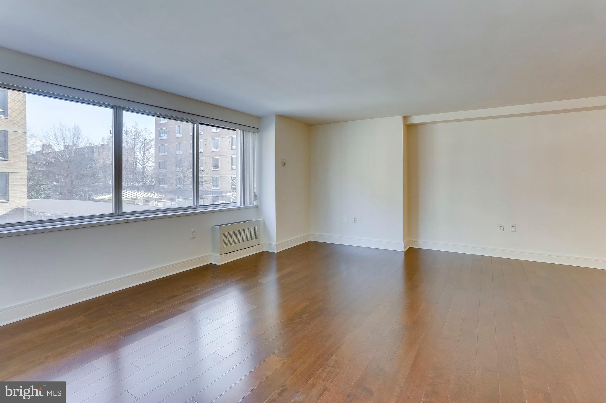 800 4th Street Southwest, Unit N111 Washington, DC 20024 - Photo 17 of 35 a view of an empty room with wooden floor and a window