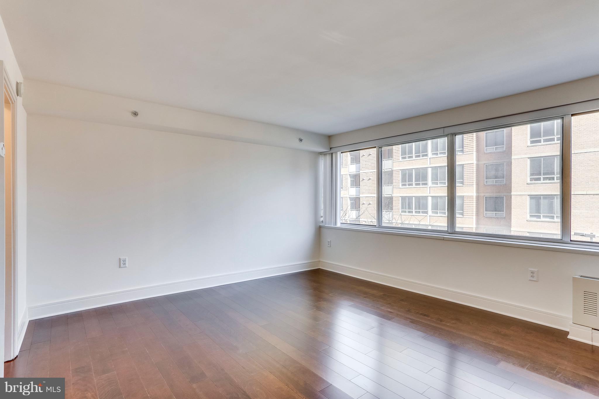 800 4th Street Southwest, Unit N111 Washington, DC 20024 - Photo 22 of 35 an empty room with wooden floor and windows