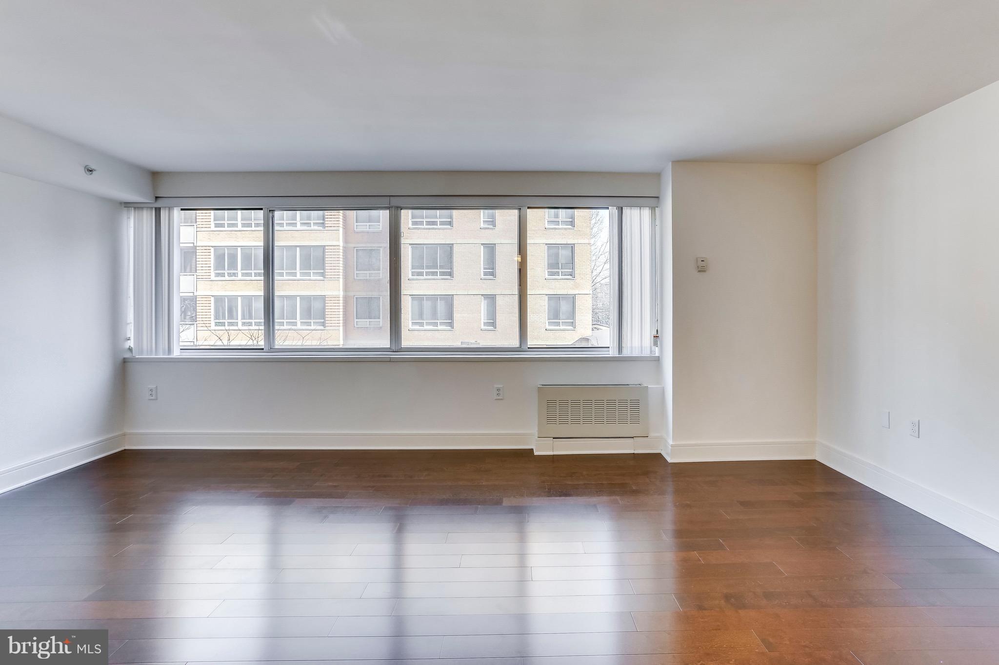 800 4th Street Southwest, Unit N111 Washington, DC 20024 - Photo 23 of 35 an empty room with wooden floor and windows