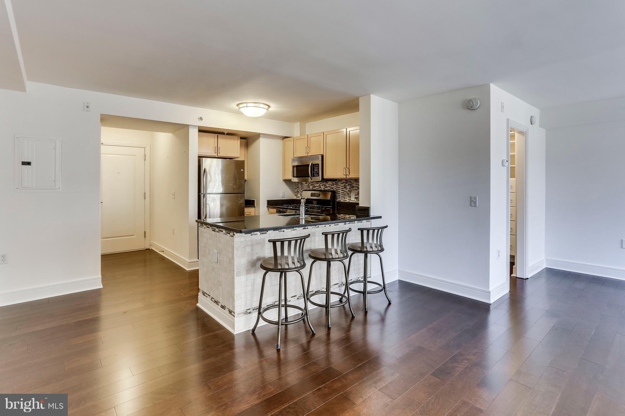 800 4th Street Southwest, Unit N111 Washington, DC 20024 - Photo 26 of 35 a kitchen with a table chairs refrigerator and cabinets
