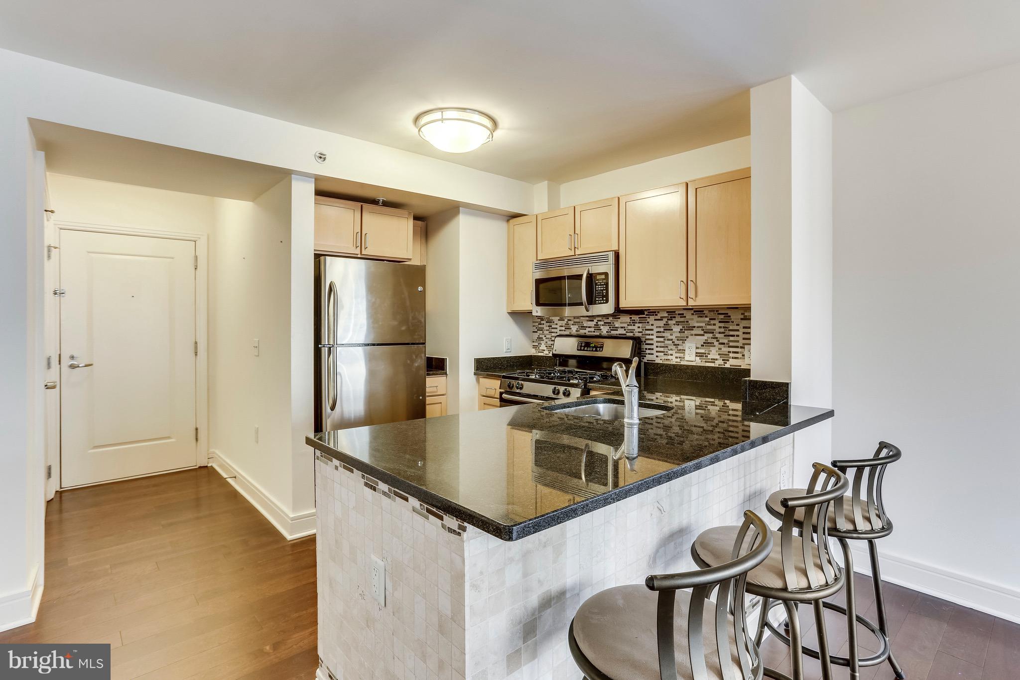 800 4th Street Southwest, Unit N111 Washington, DC 20024 - Photo 9 of 35 a kitchen with stainless steel appliances granite countertop a refrigerator a stove and a sink with granite countertops