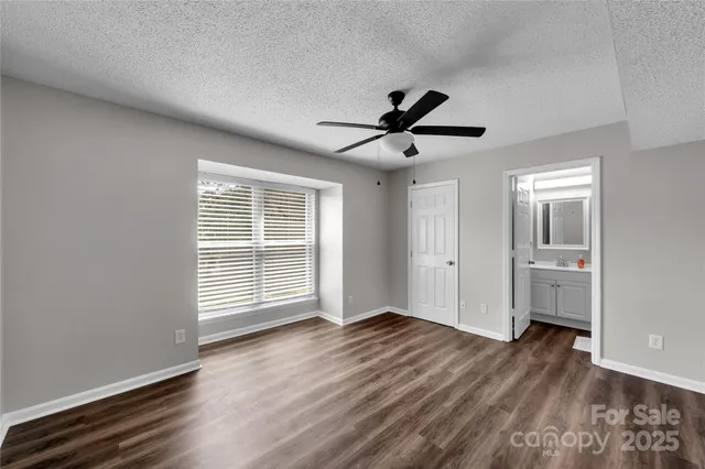 a view of a livingroom with wooden floor and a ceiling fan