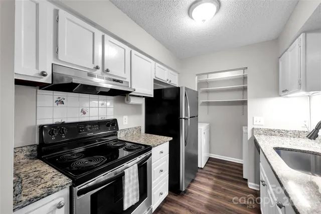 a kitchen with stainless steel appliances granite countertop a stove and a refrigerator