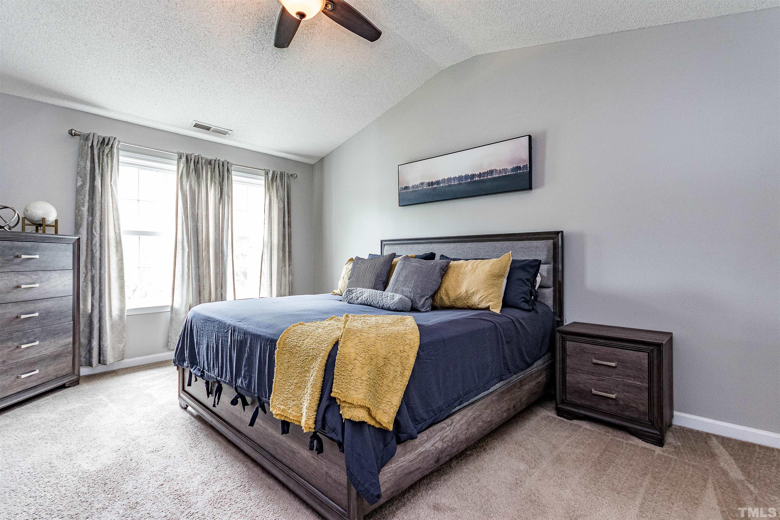 107 Ridge Lake Drive Apex, NC 27539 - Photo 17 of 27 a bed sitting in a bedroom next to a window and a chair