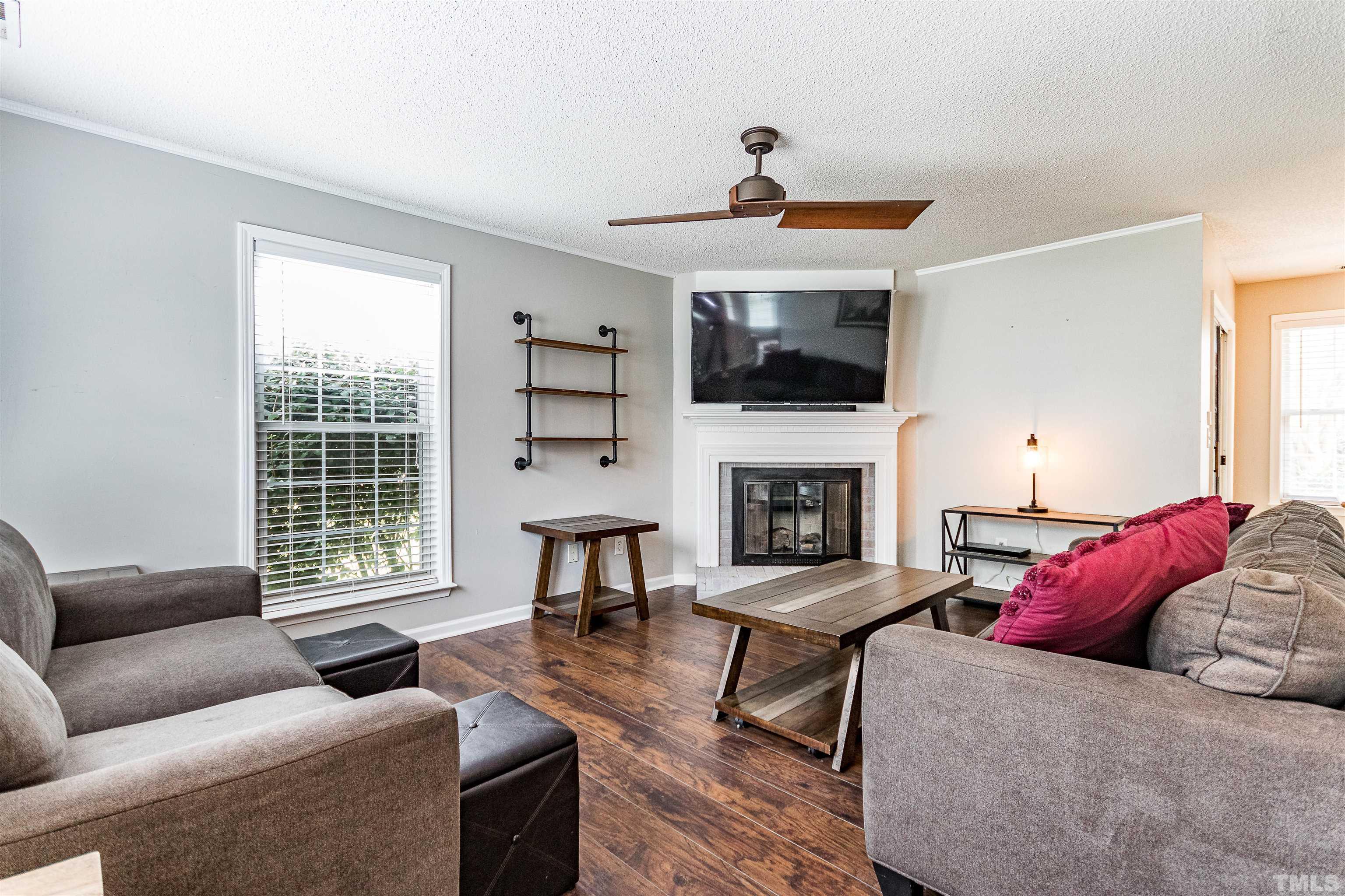 107 Ridge Lake Drive Apex, NC 27539 - Photo 4 of 27 a living room with furniture a fireplace and a flat screen tv