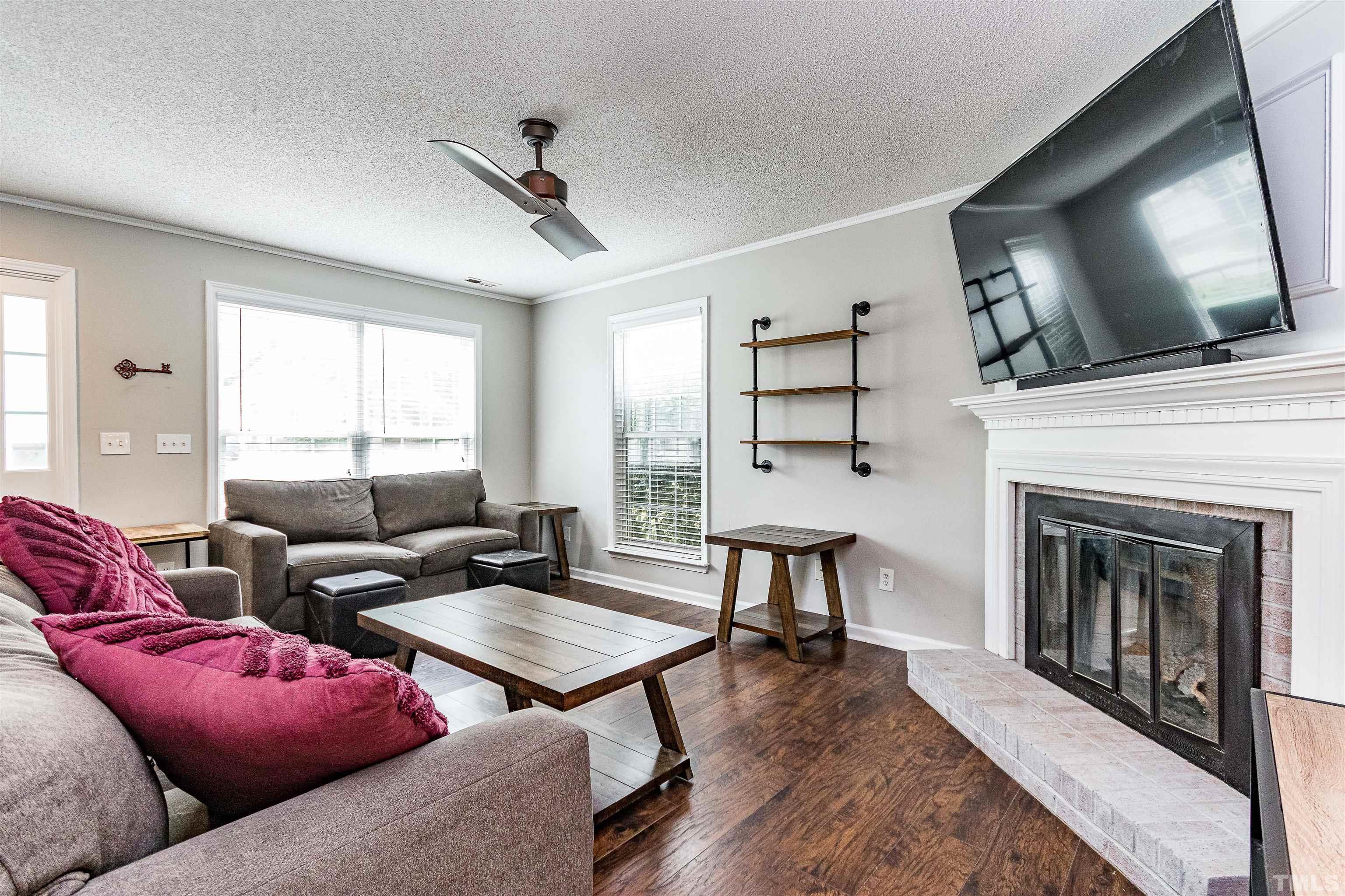 107 Ridge Lake Drive Apex, NC 27539 - Photo 6 of 27 a living room with furniture a flat screen tv and a fireplace