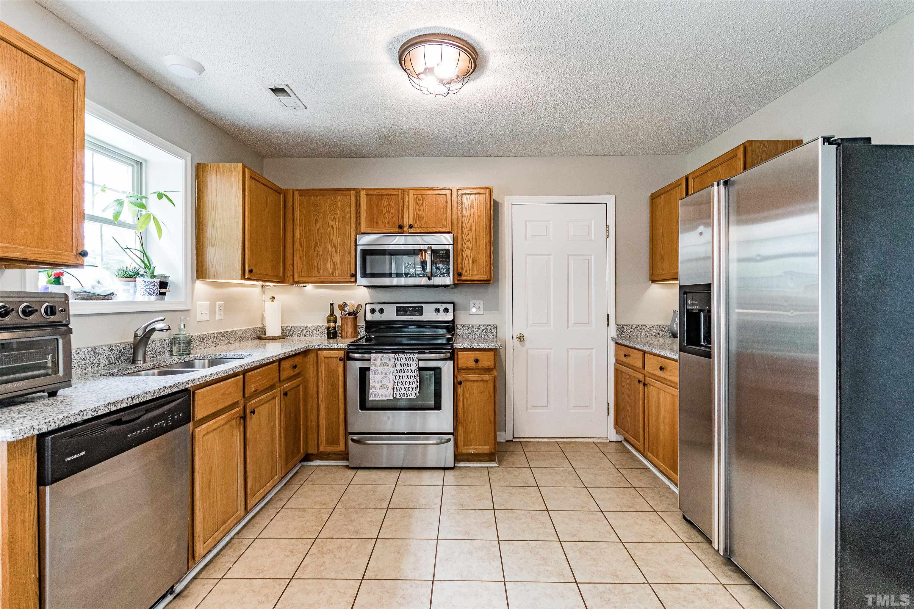 107 Ridge Lake Drive Apex, NC 27539 - Photo 8 of 27 a kitchen with stainless steel appliances granite countertop a refrigerator and a stove top oven