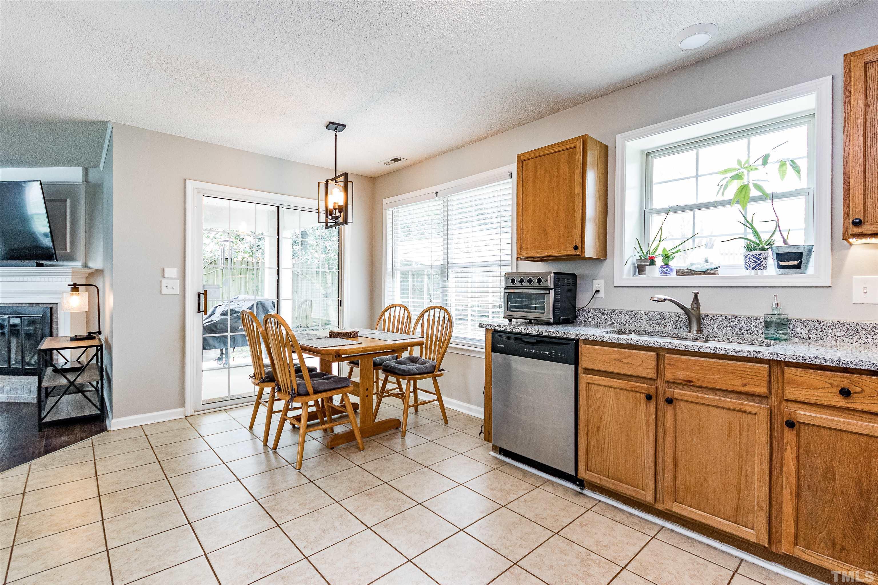 107 Ridge Lake Drive Apex, NC 27539 - Photo 9 of 27 a kitchen with granite countertop a sink dining table and chairs