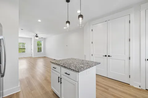 an empty room with windows and fan