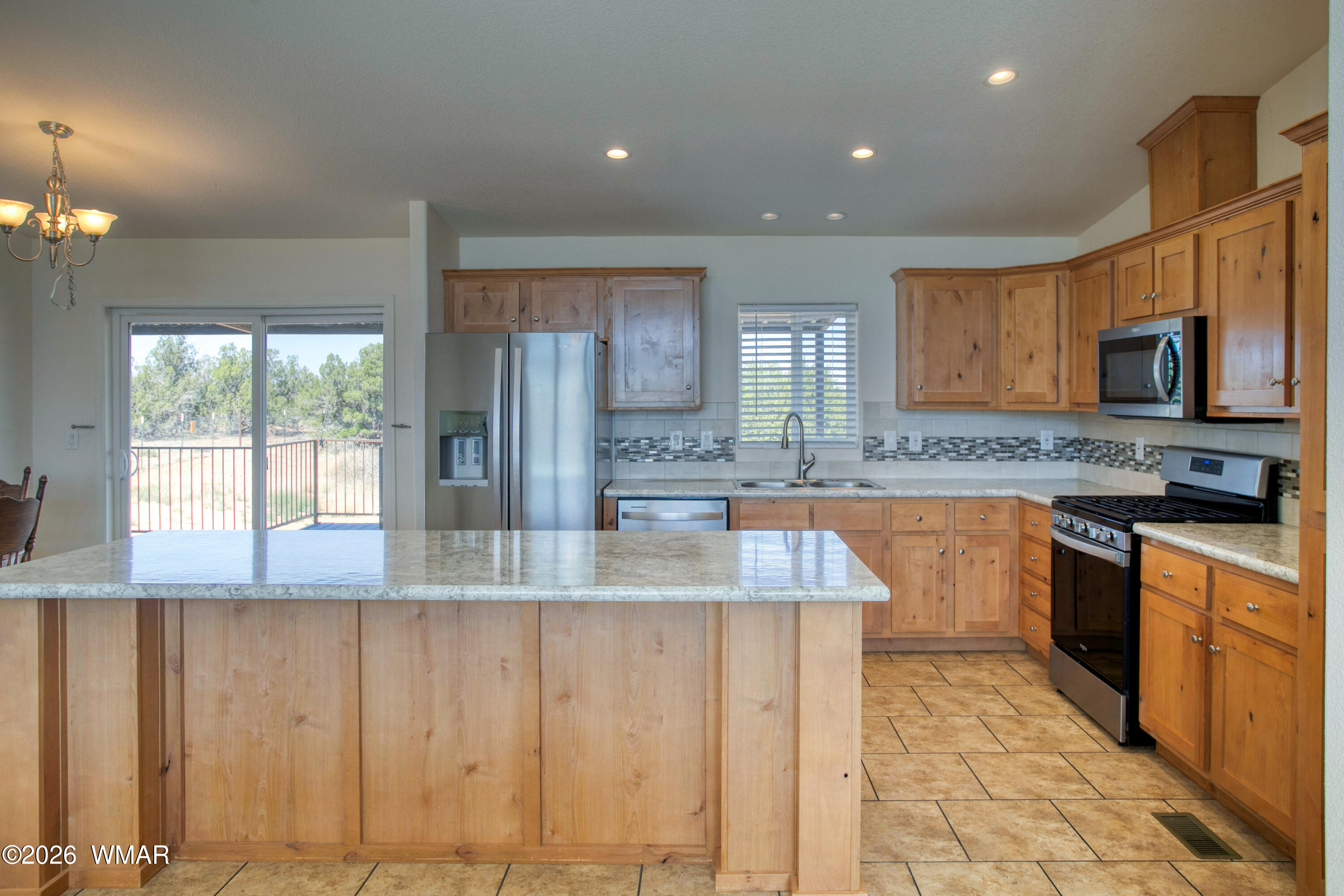3869 Petersen Road Snowflake, AZ 85937 - Photo 5 of 29 a large kitchen with granite countertop a stove a sink and a microwave