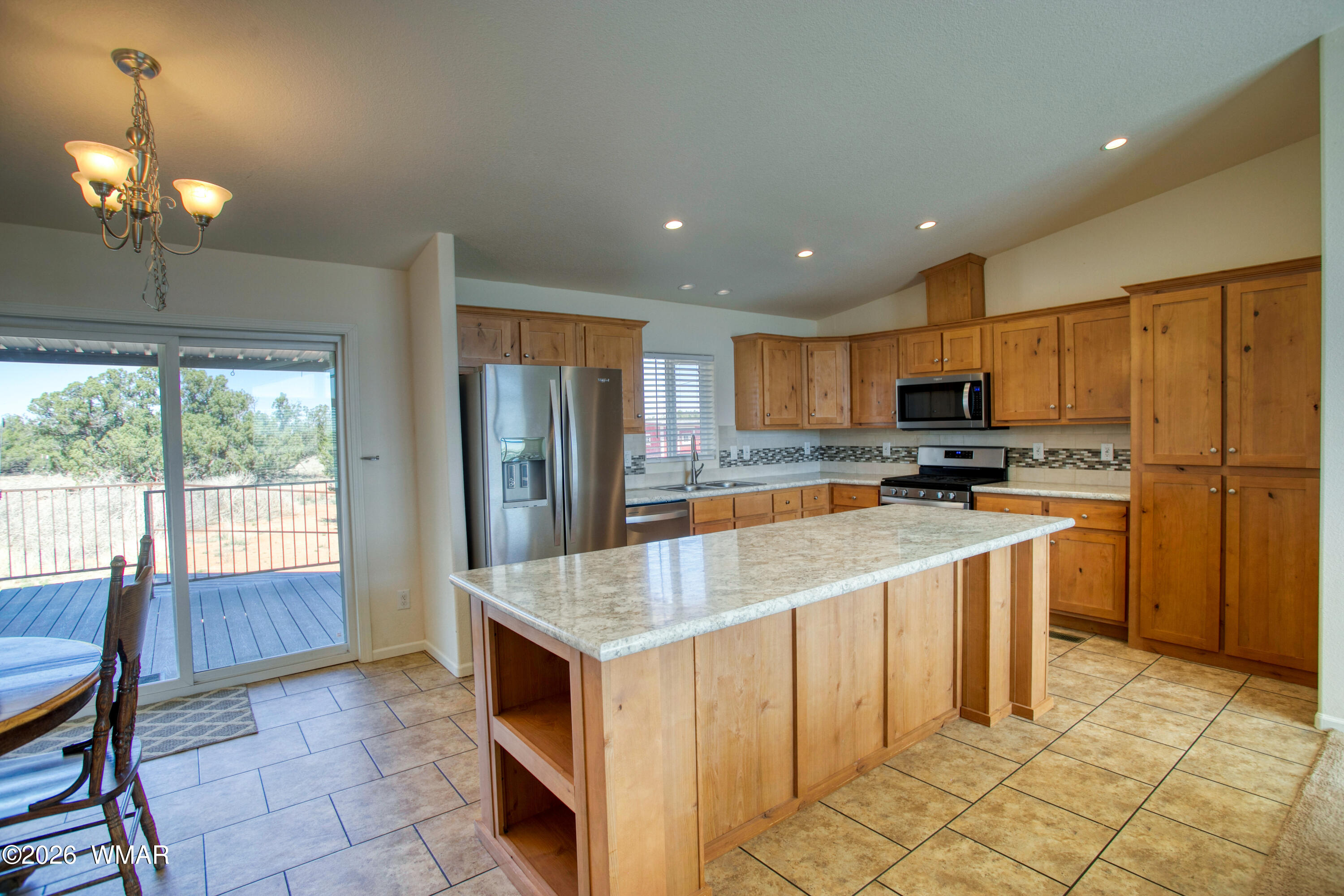 3869 Petersen Road Snowflake, AZ 85937 - Photo 9 of 29 a kitchen with stainless steel appliances granite countertop a refrigerator oven a sink dishwasher and white cabinets with wooden floor