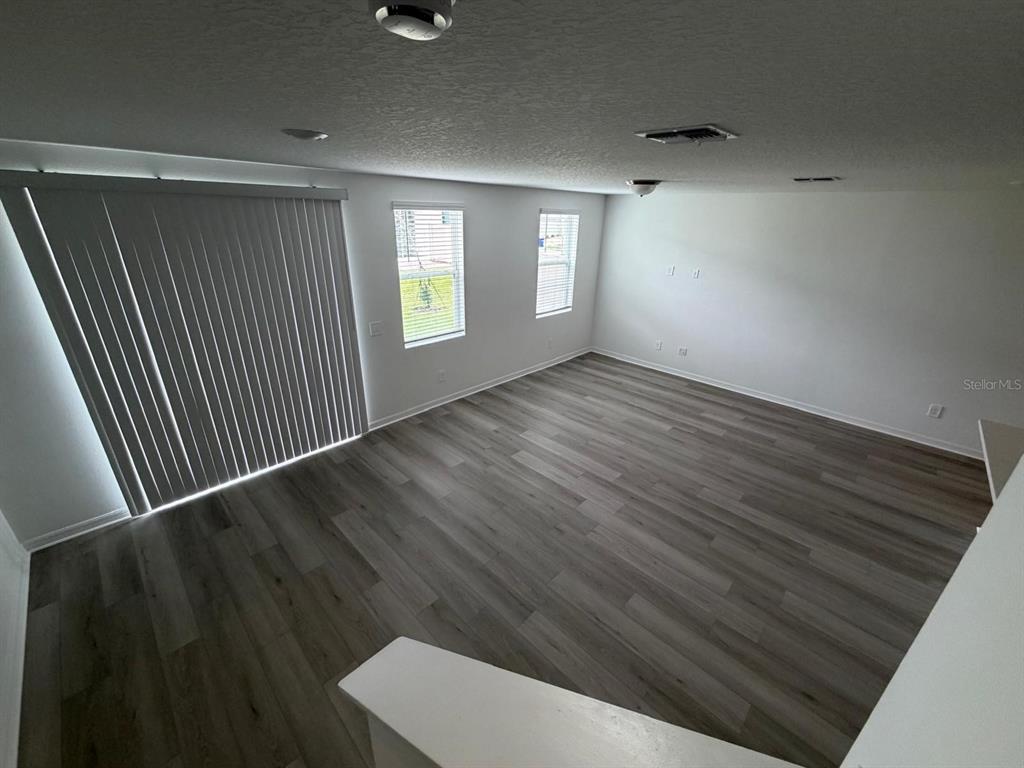 4264 Ranch House Road St. Cloud, FL 34772 - Photo 10 of 34 an empty room with wooden floor and windows