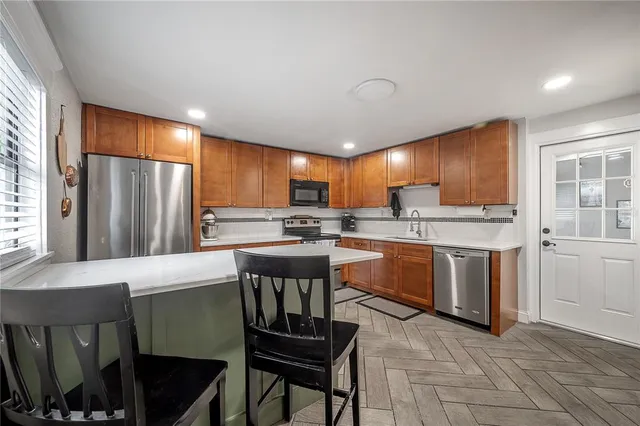 a kitchen with stainless steel appliances granite countertop a stove refrigerator sink and cabinets