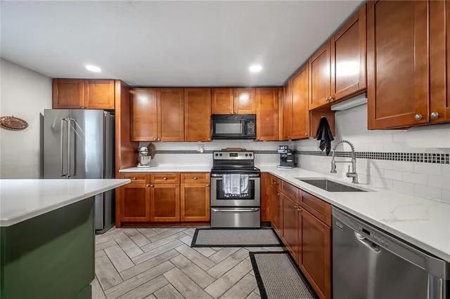 a kitchen with stainless steel appliances granite countertop a sink stove and refrigerator