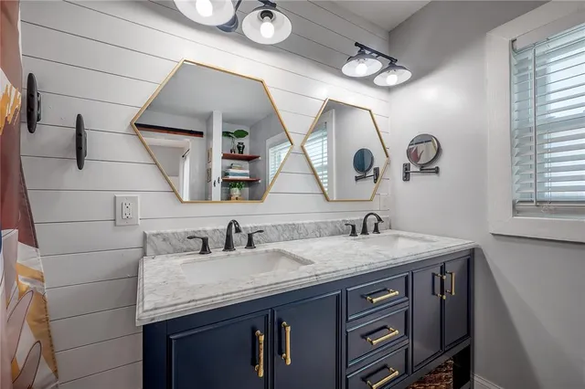 a bathroom with a granite countertop sink a large mirror and vanity