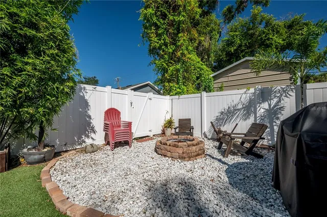 a backyard of a house with barbeque oven fire pit table and chairs