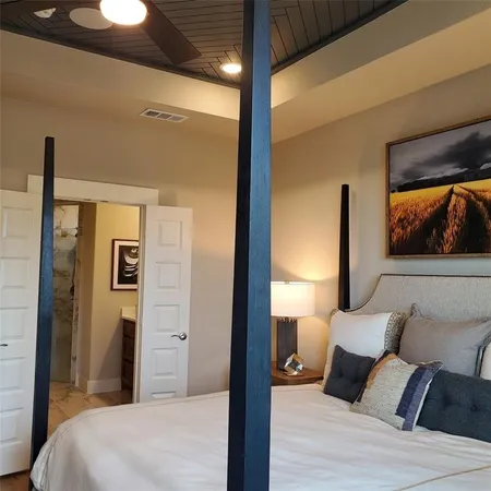 a bedroom with a bed and a painting on the wall