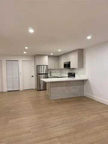 a kitchen with stainless steel appliances granite countertop a stove a sink and a refrigerator