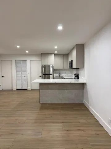 a view living room with stainless steel appliances kitchen island sink refrigerator and stove