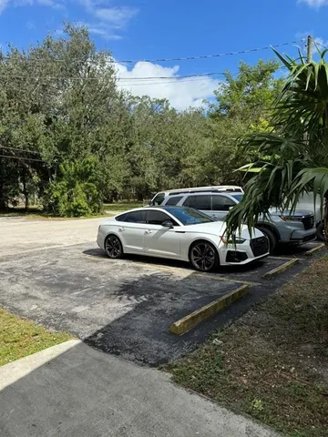 a view of a backyard with a car parked on the road