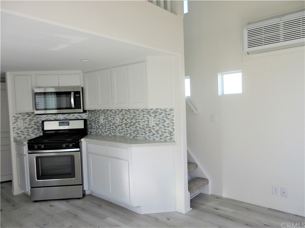 105 Sandy Drive San Clemente, CA 92672 - Photo 5 of 17 Kitchen; wood like flooring, custom backsplash, wall unit AC