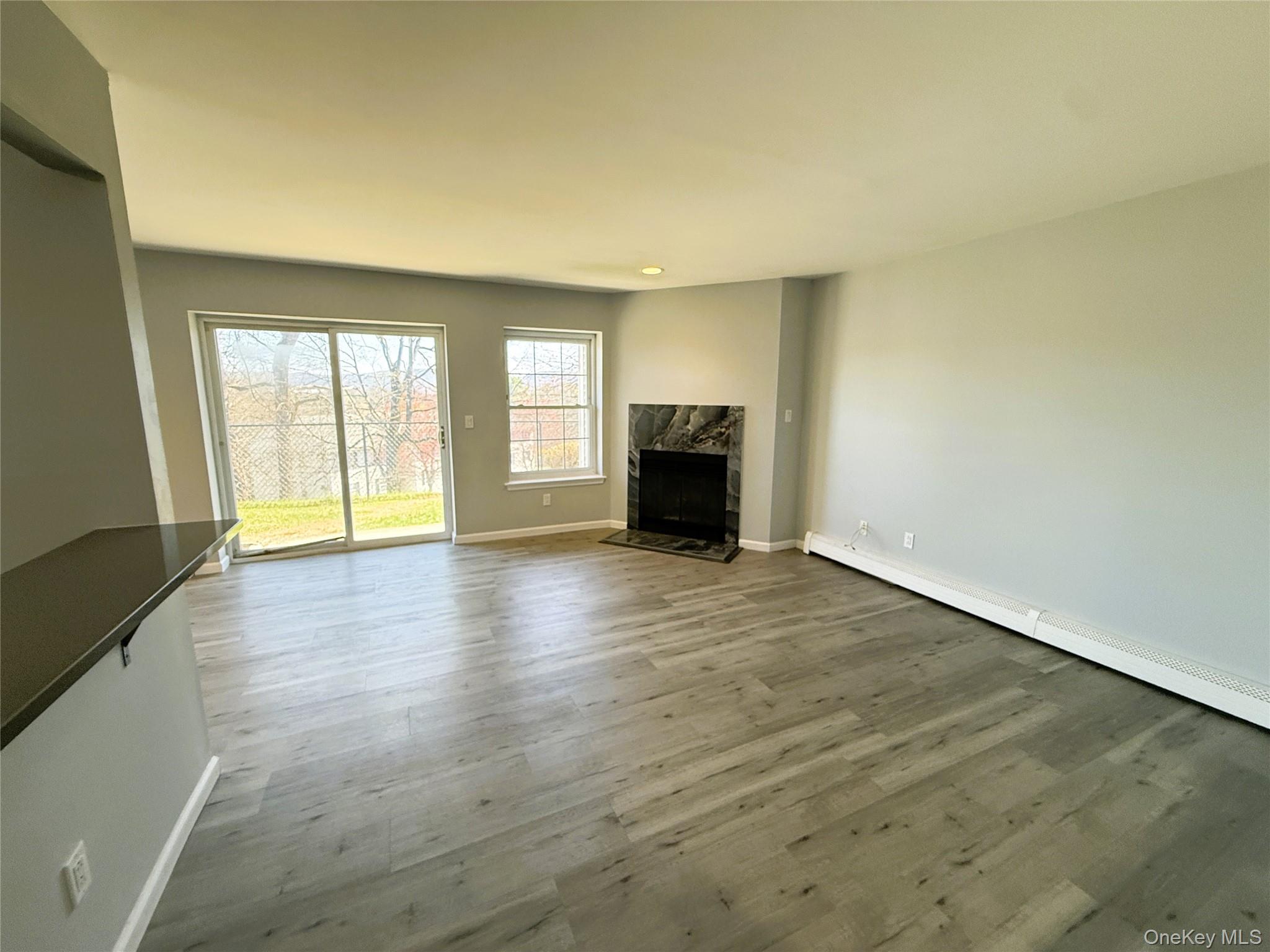 25 Lexington Hills Road, Unit 8 Harriman, NY 10926 - Photo 11 of 24 an empty room with wooden floor and fireplace