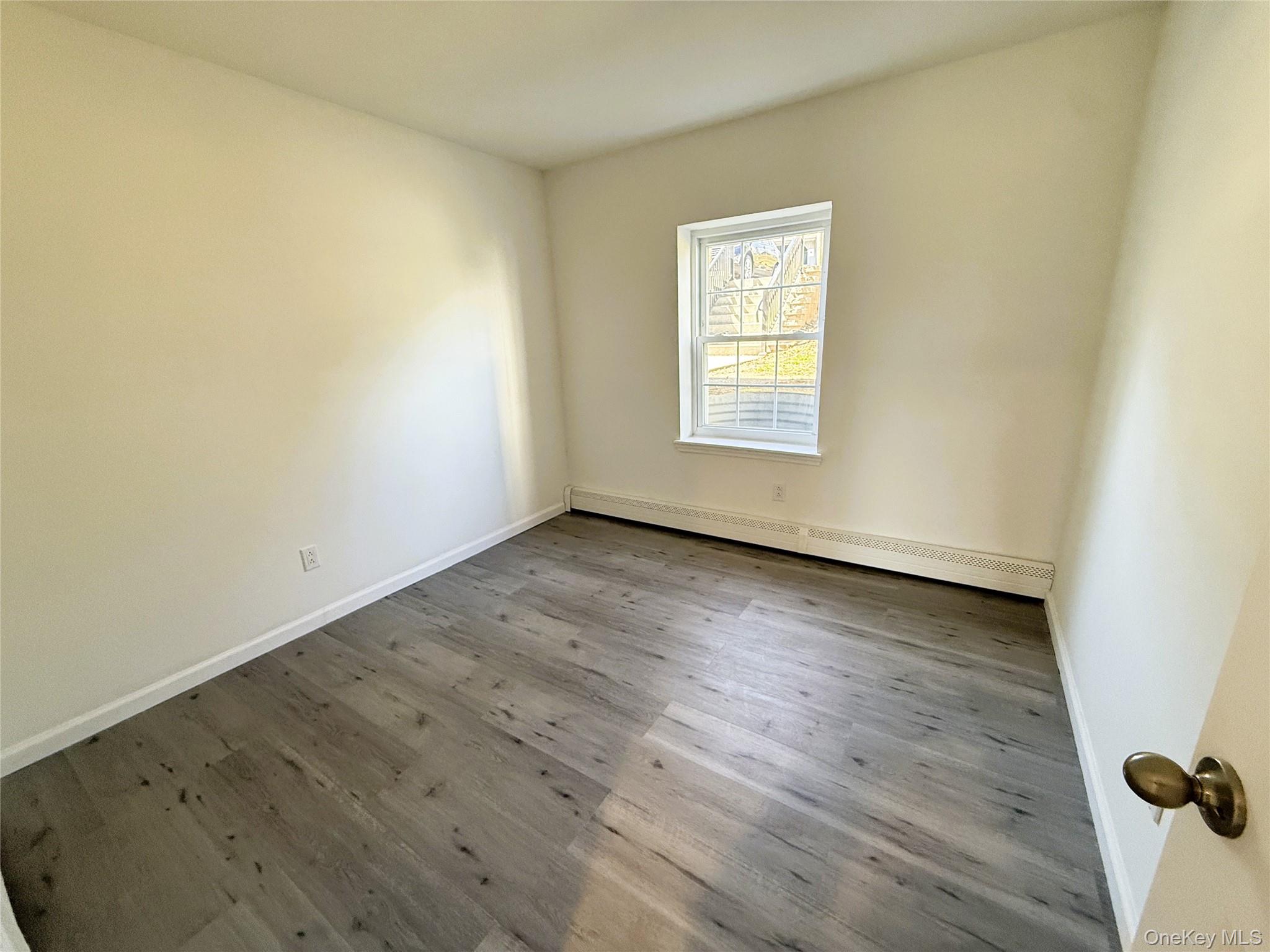 25 Lexington Hills Road, Unit 8 Harriman, NY 10926 - Photo 14 of 24 an empty room with wooden floor and windows