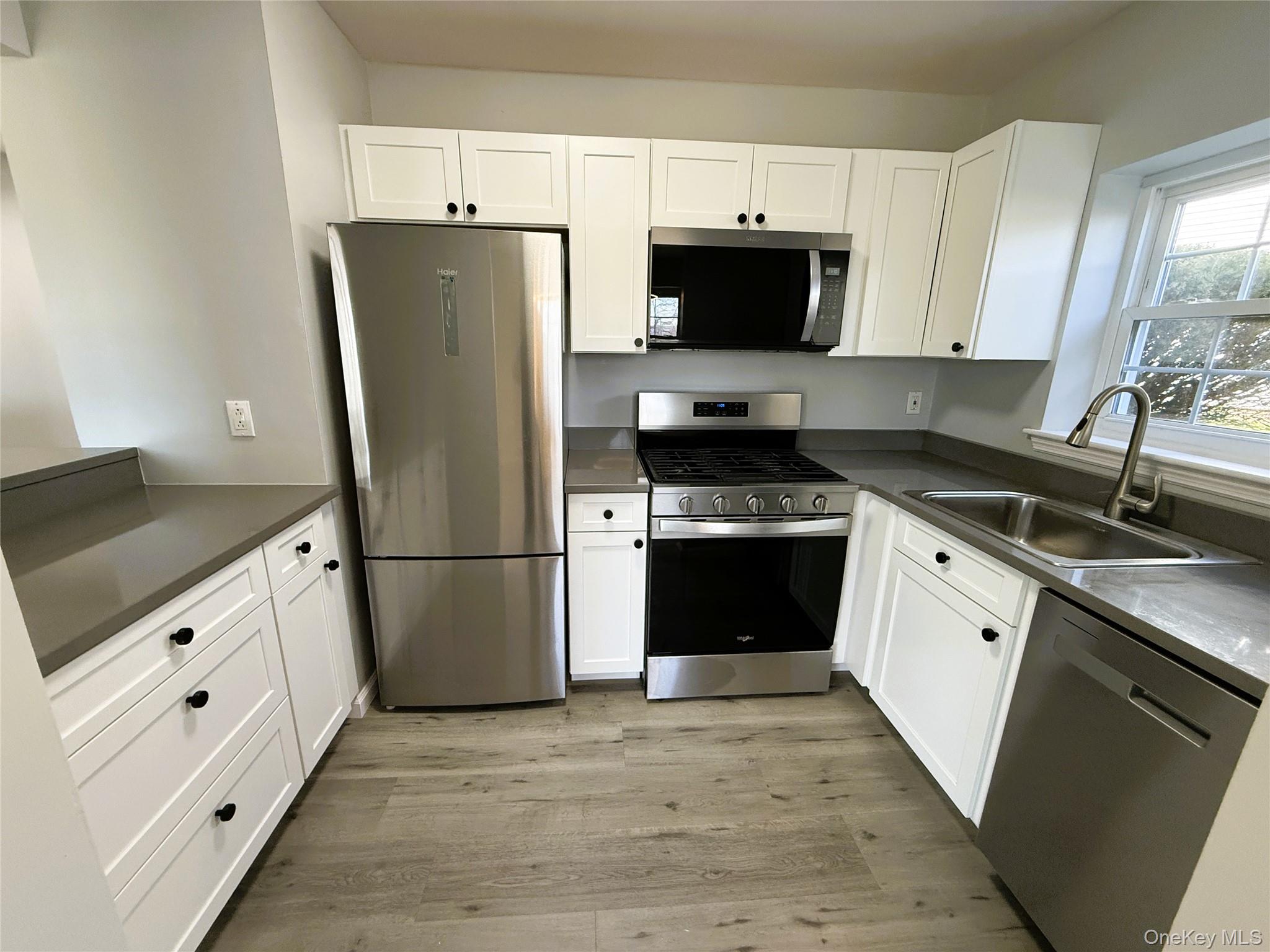 25 Lexington Hills Road, Unit 8 Harriman, NY 10926 - Photo 2 of 24 a kitchen with white cabinets and white appliances